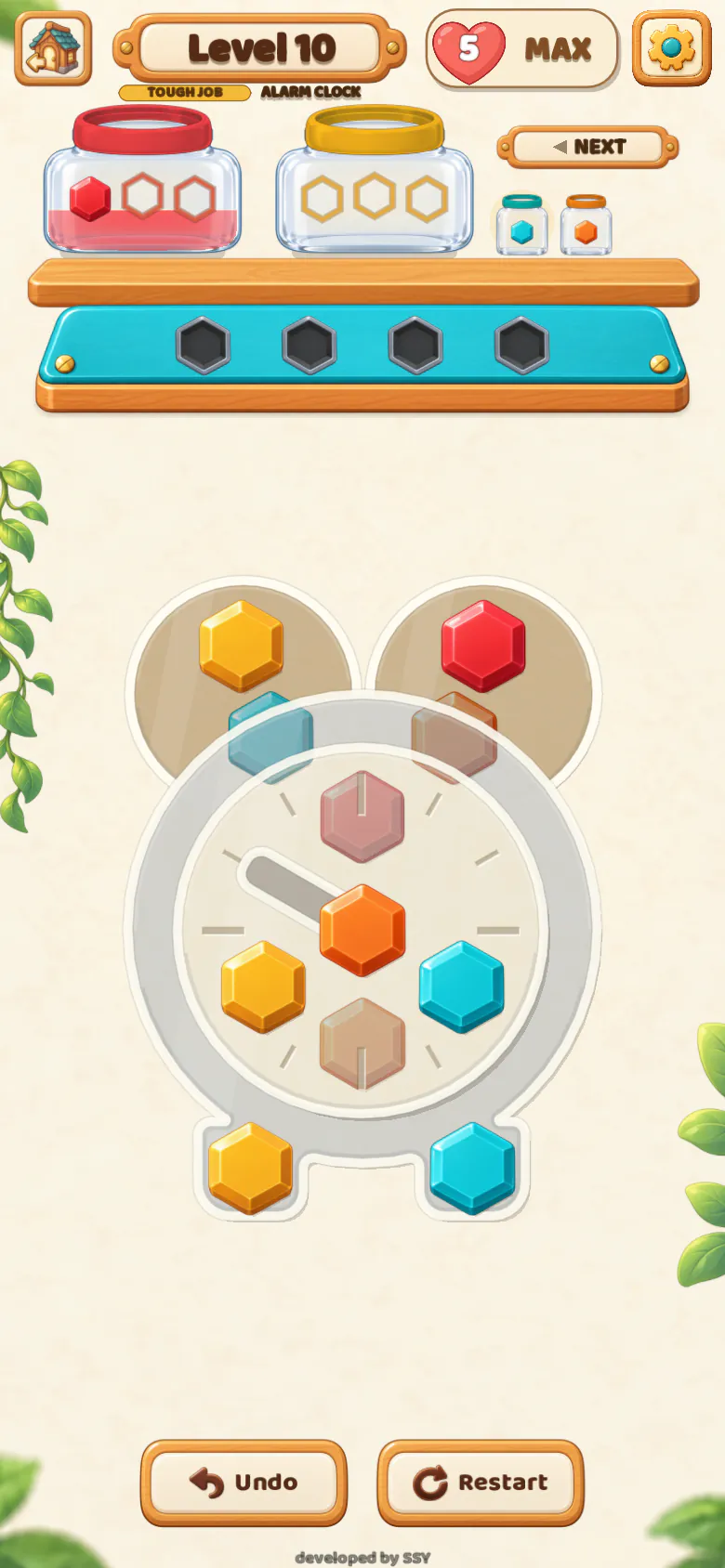 Level 10 of Boltie Beaver, a tough job shaped like an alarm clock: coloured bolts on the clock’s glass face and bells, with two jars and the bench above and Undo and Restart below